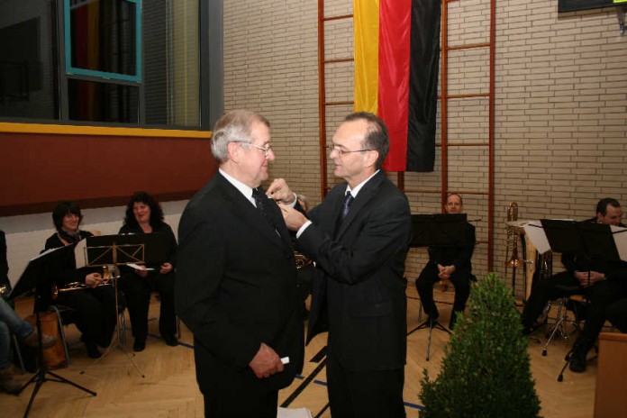 img-120559-Landrat Dr. Brechtel steckt Weis die Auszeichung an.jpg